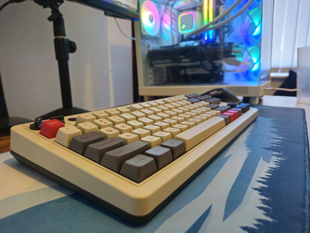 Close-up of a professional mechanical keyboard in a development workspace with a colorful blue and white mouse pad, representing coding and open source collaboration